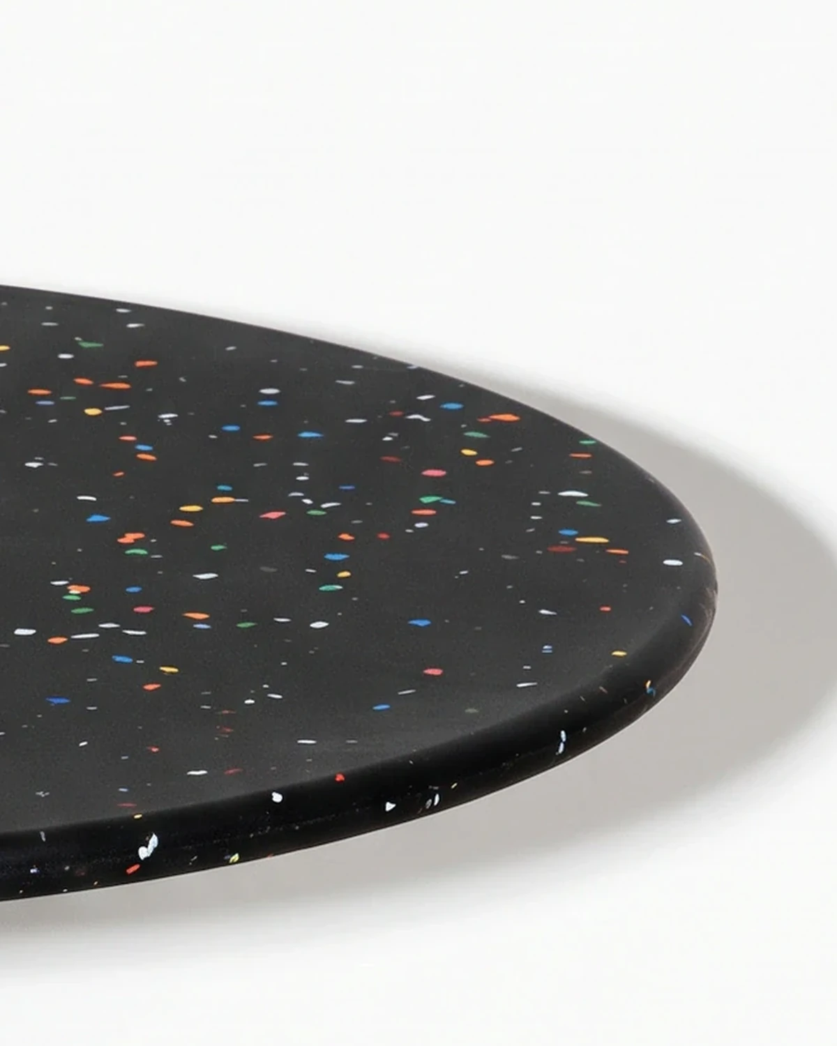 Potter, stacked-disc table Ø80 × 52, black, colour flecks: top corner close-up