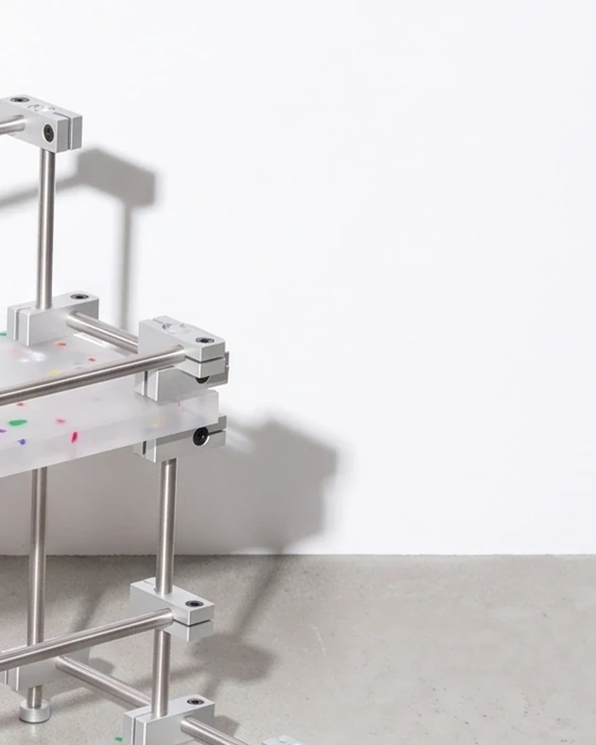 Apothecary, two-tier riser with raised edges 40 × 20, translucent, colour flecks: top corner close-up