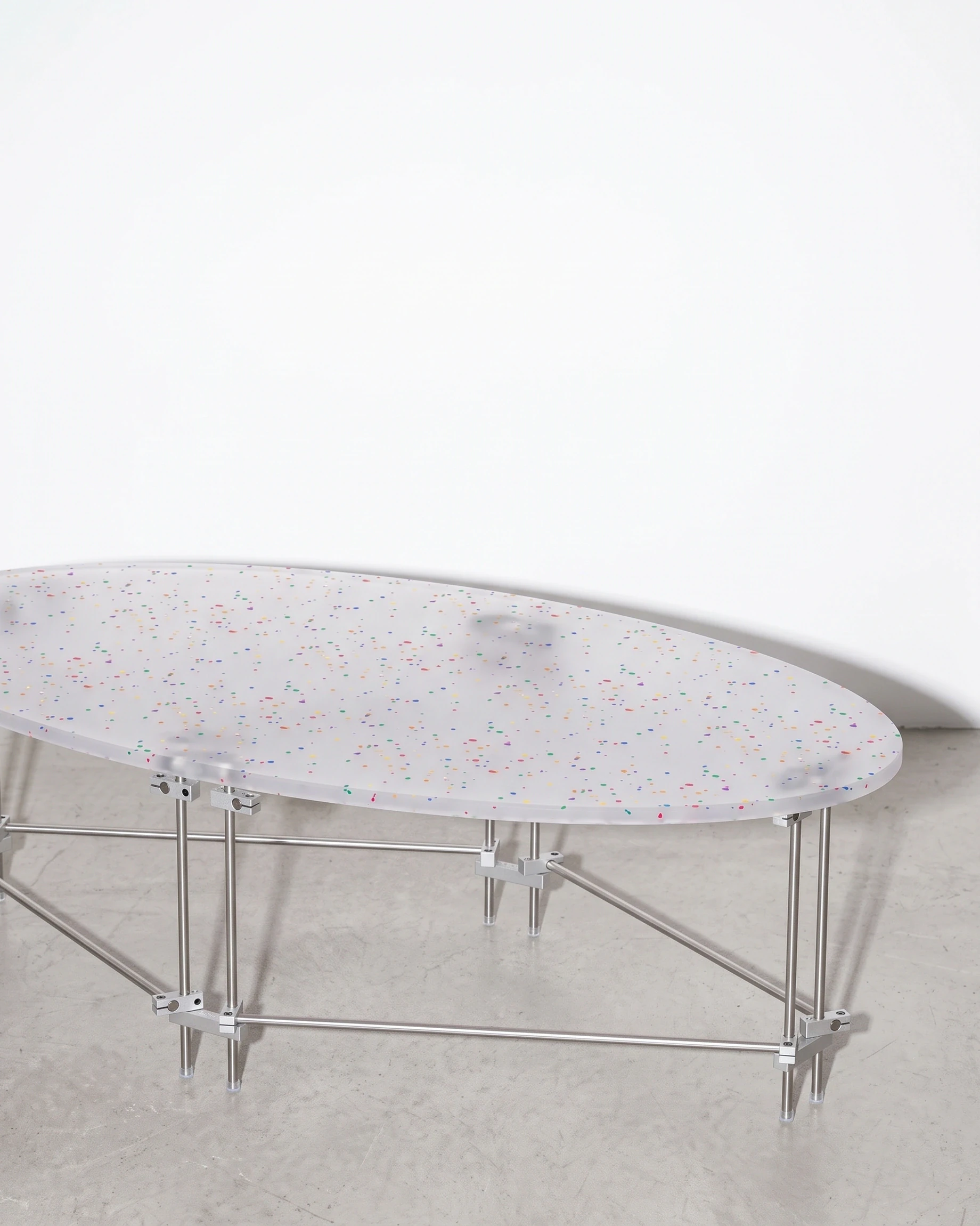 Surfer, oval coffee table 120 × 70, translucent, colour flecks: front right view